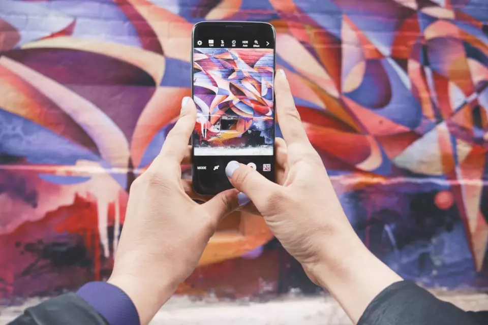 Someone taking pictures of a mural for a social image