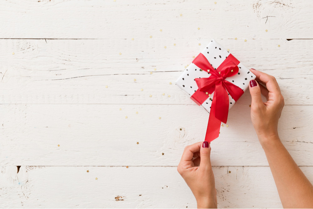 Influencer unwrapping present for holiday influencer campaign. 