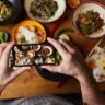 Someone taking a picture on their smartphone of dishes of food
