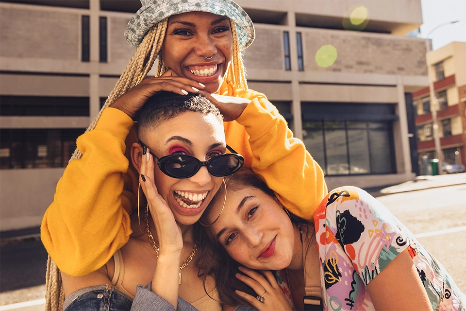 Three women smiling for the camera as an example of influencer campaign ideas to keep things fresh