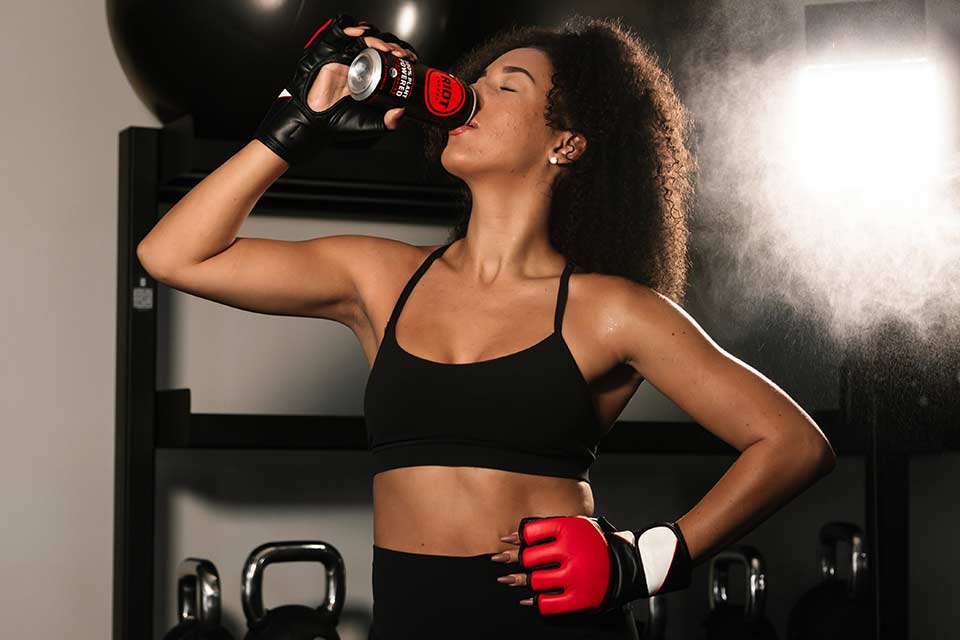 Woman drinking from a can during a workout