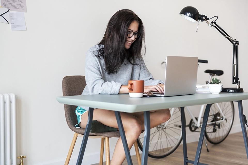 Woman working from home on a laptop at a table
