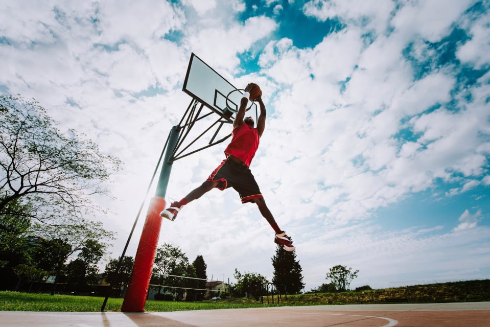 Basketball player making a slam dunk on a beautiful day