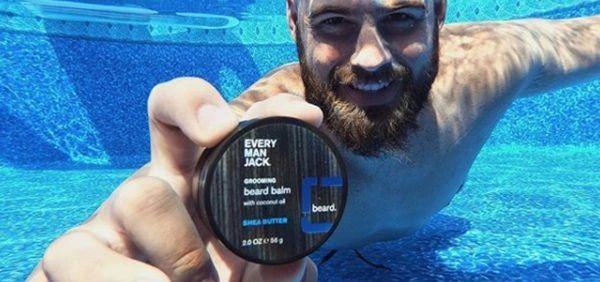 Man underwater holding up an Every Man Jack product