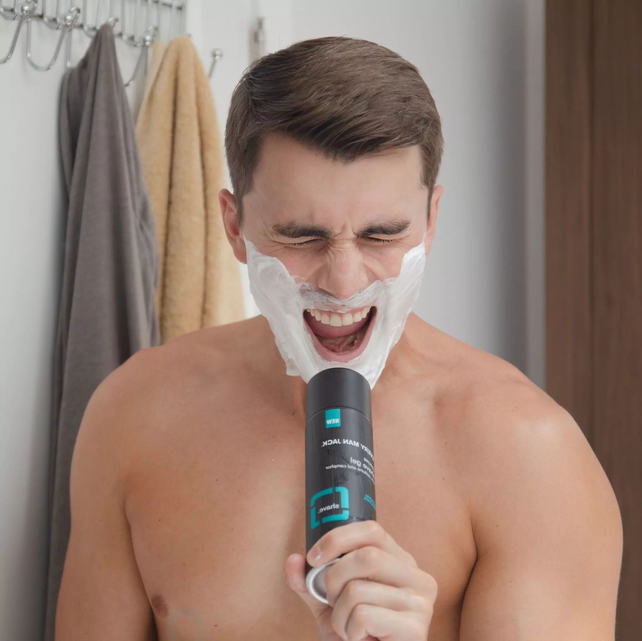 Man singing in the shower with a bottle of Every Man Jack, a men's skincare brand