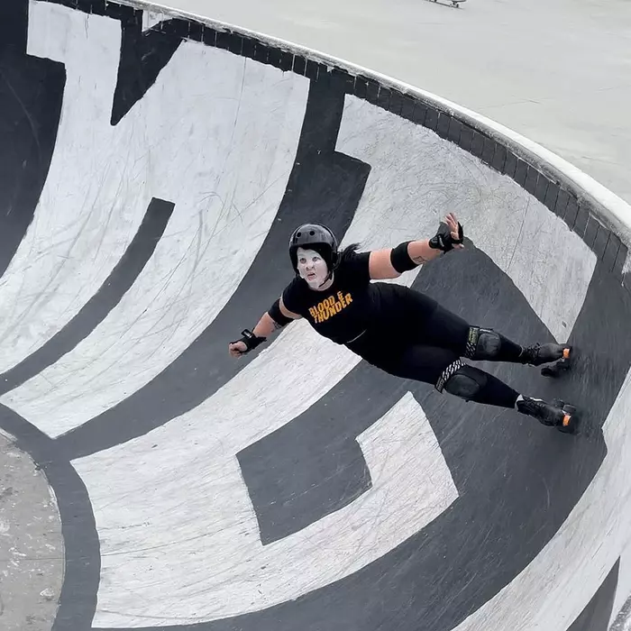 Woman roller skating in a skate park with a cosmetic facial mask on