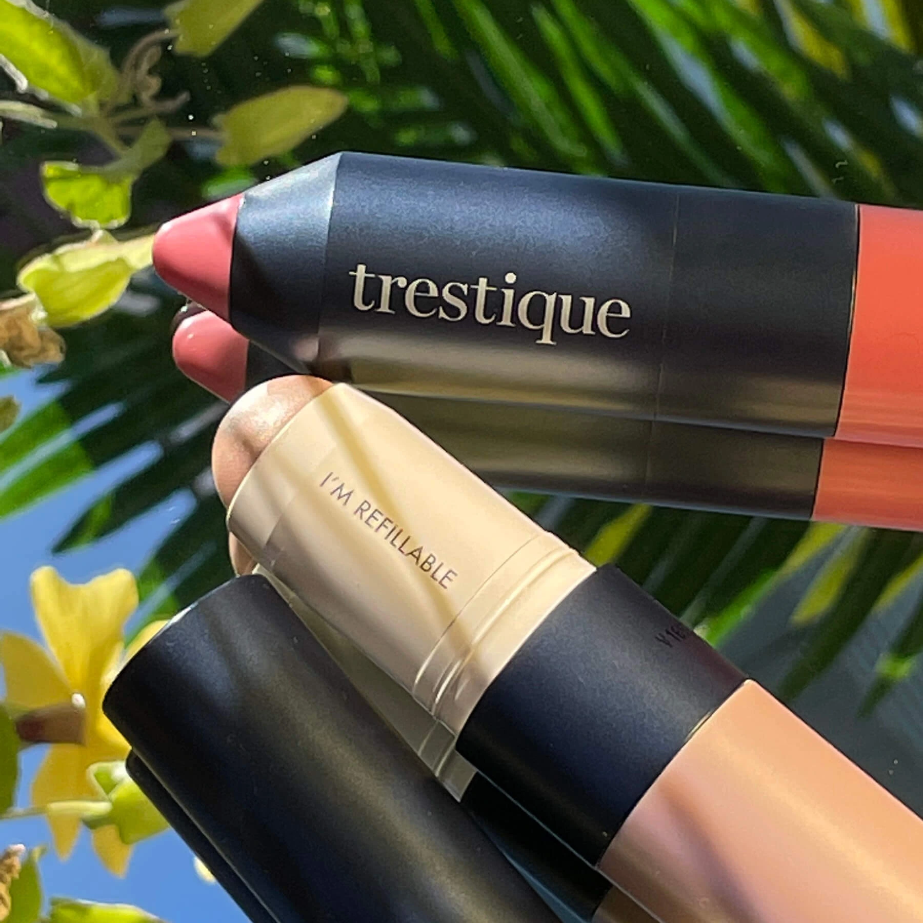 trestique products against a blue sky with foliage indicating a sustainable beauty brand