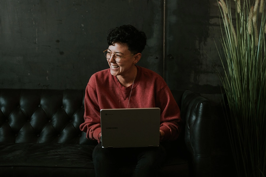 Someone smiling with a computer on a couch about influencer marketing SEO