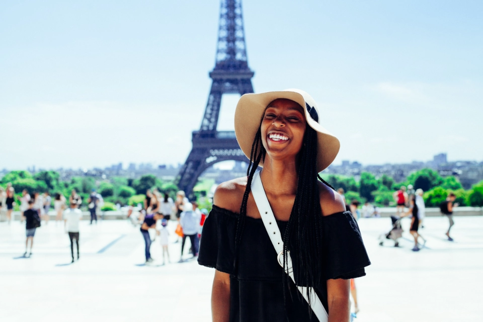 travel influencer smiling in front of the Eiffel Tower