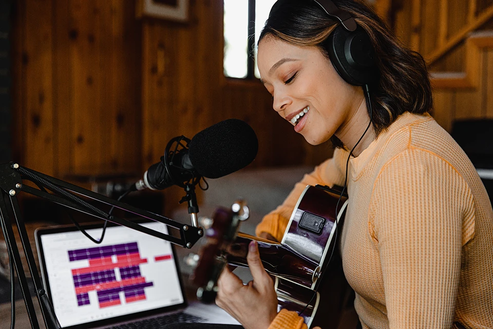 woman recording a song with a guitar for influencer marketing for music