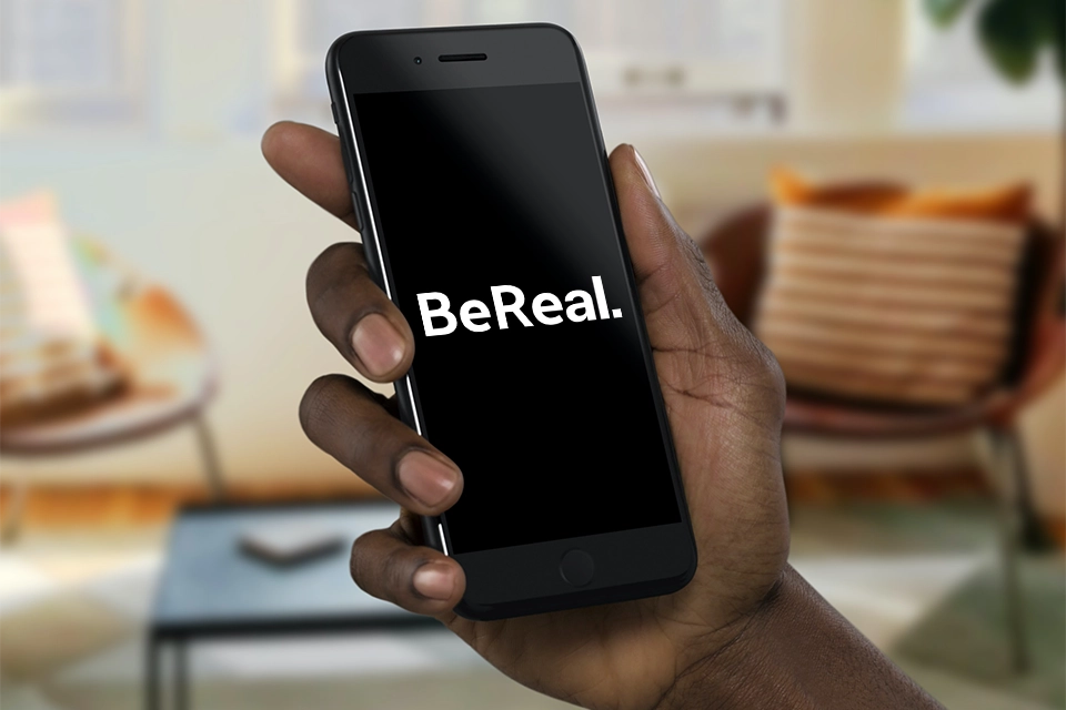 a hand holding a smart phone with BeReal on it symbolizing social media trends today