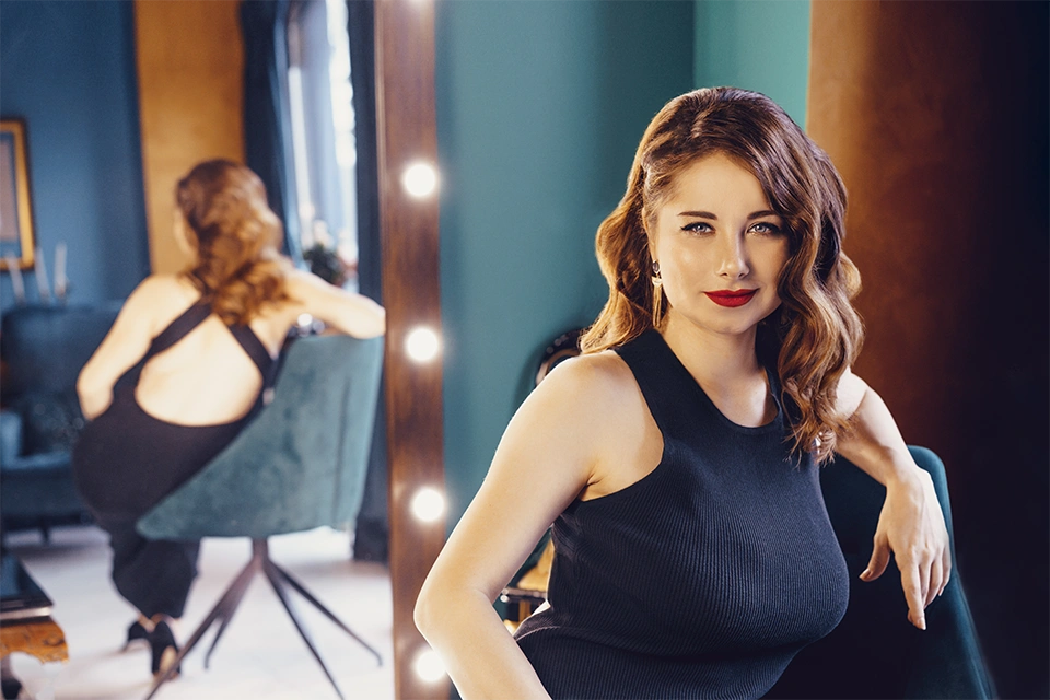 best celebrity endorsements represented by a beautiful woman in a black dress sitting in front of a mirror