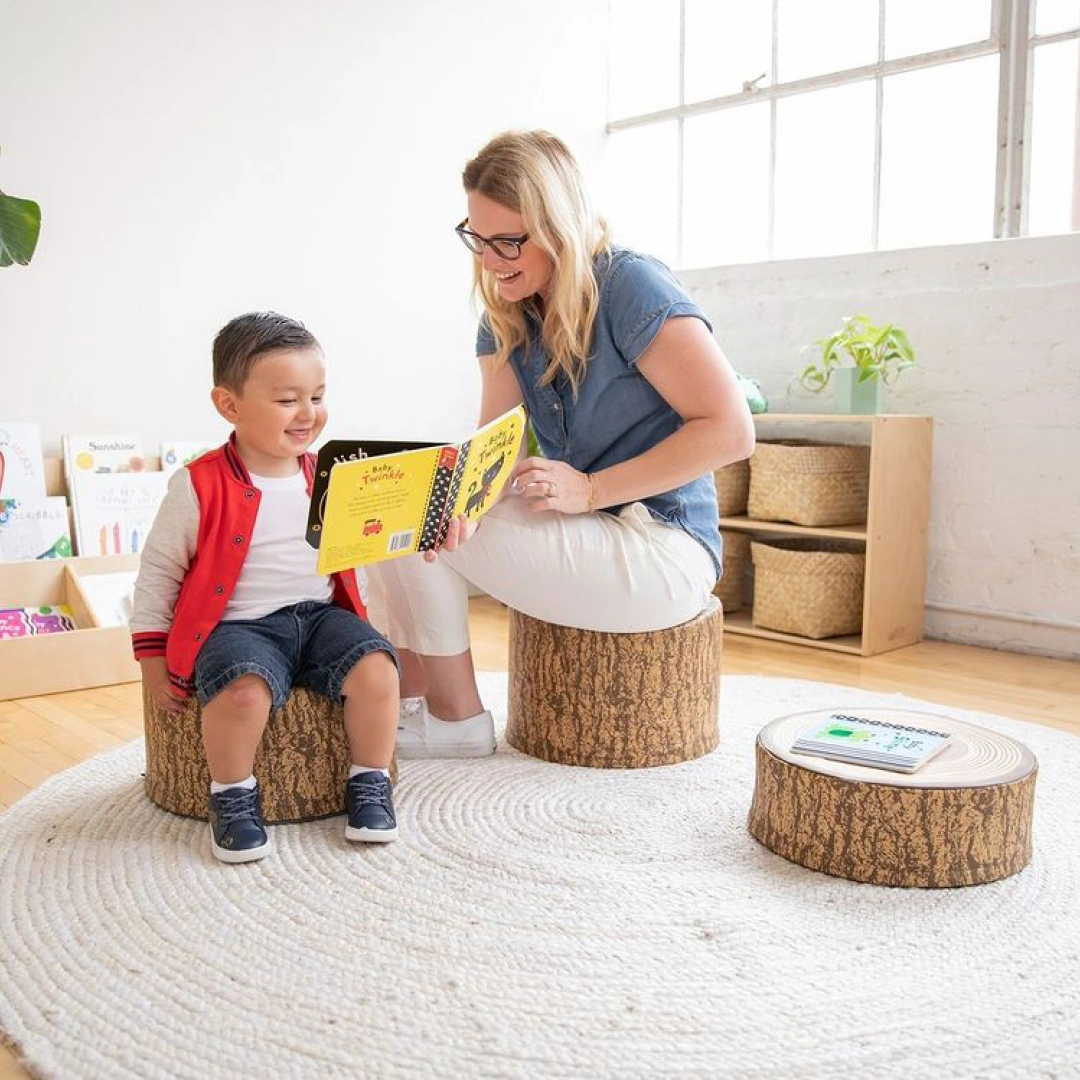 woman reading a book to a child in a living room