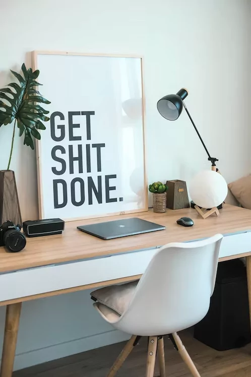 Work desk with Get Shit Done sign leaning against the wall