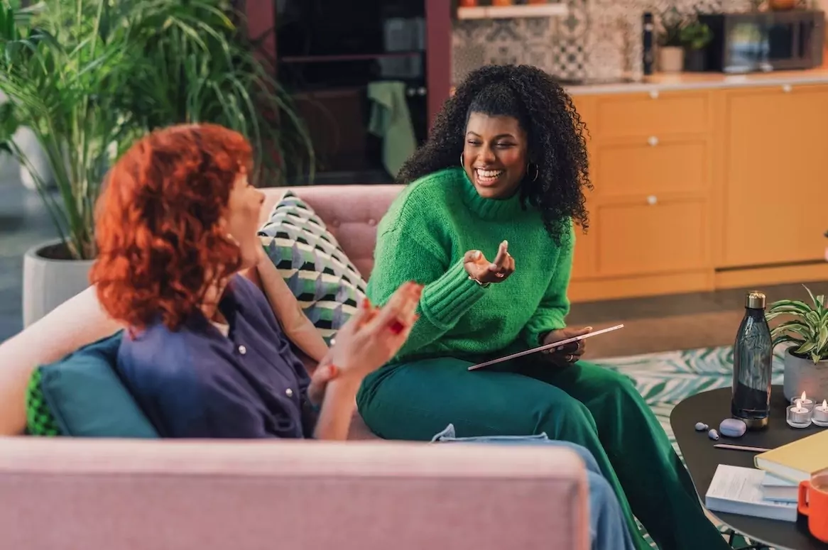 Two women laughing on a couch