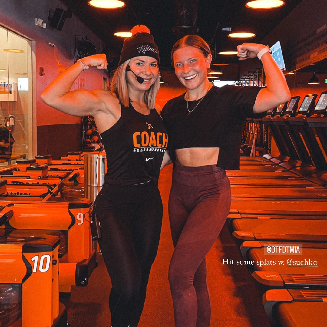 Instructor and attendee at Orangetheory flexing