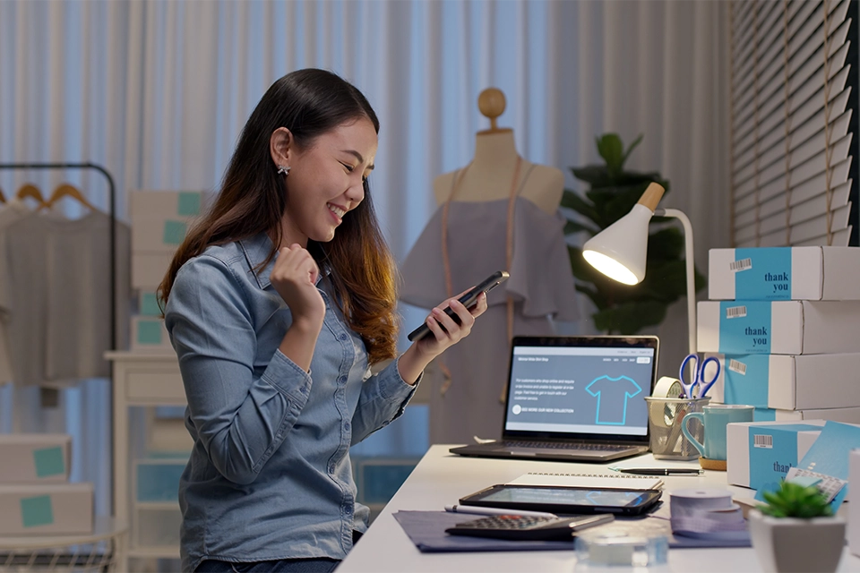 Woman smiling at a phone about how to measure brand reputation