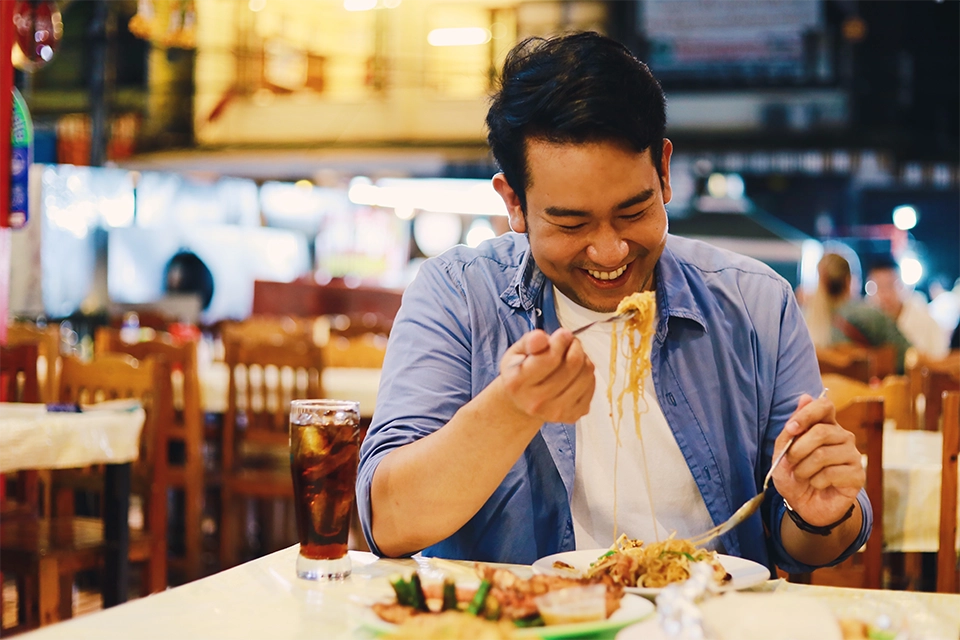 A man eating pasta while laughing representing restaurant influencers