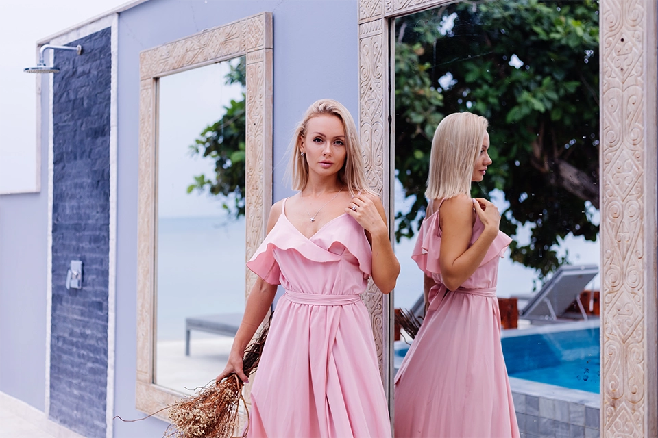a blonde woman in a pink dress symbolizing luxury travel influencers