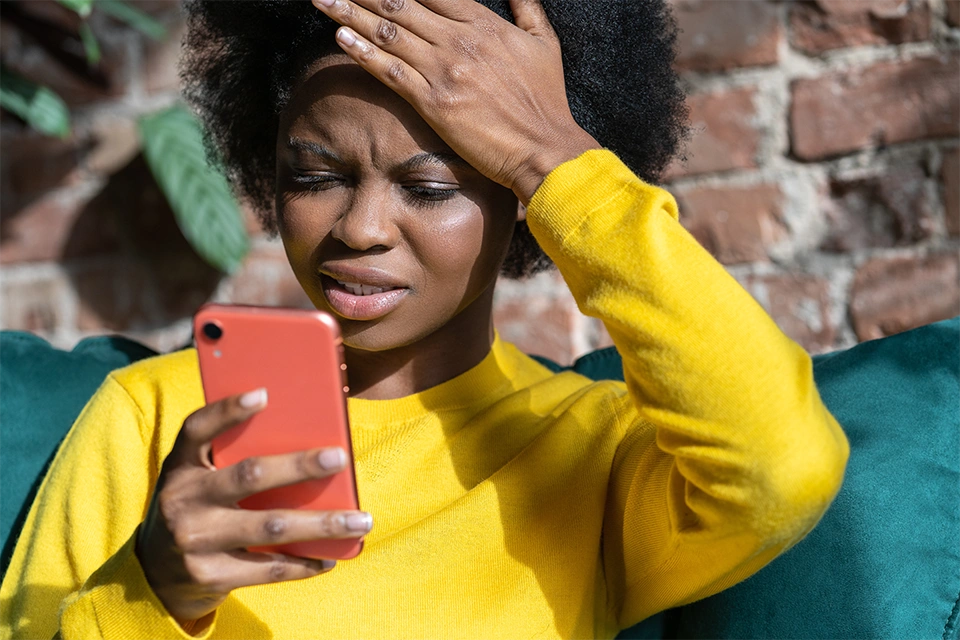 Woman frustrated by influencer scams on her phone