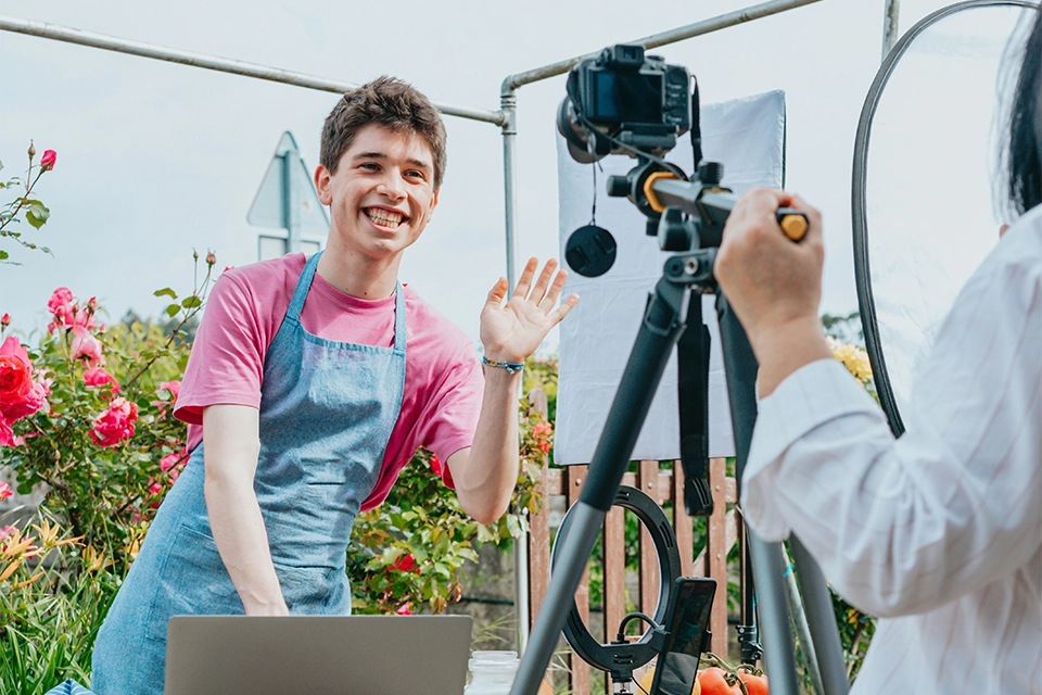 Influencer with an apron getting filmed by a camera for social media marketing