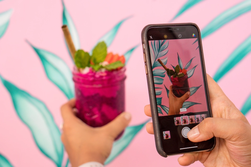 Someone taking a photo of a tropical drink as an example of Instagram story ideas