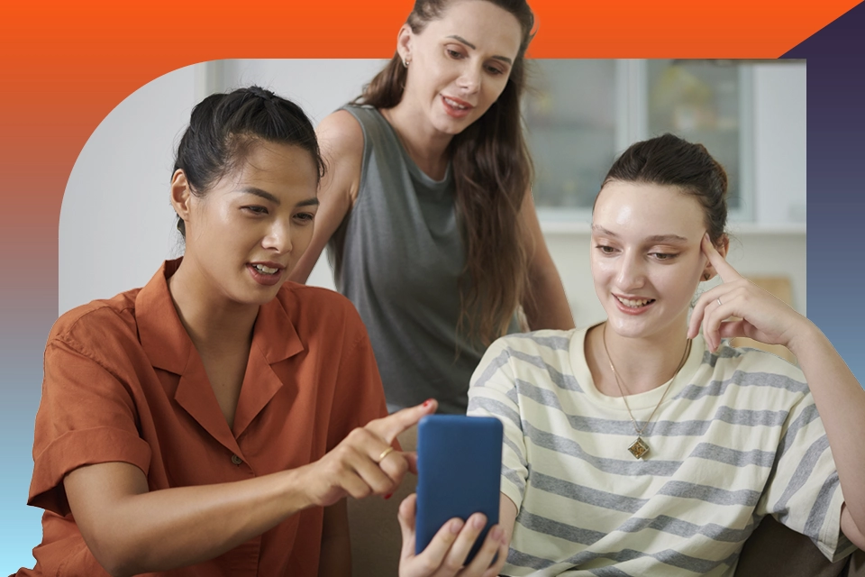 Three women looking at a phone symbolizing online reputation management for businesses